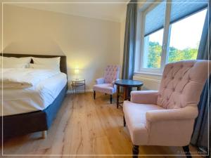 a bedroom with a bed and a chair and a window at Saar-Apartments in Merzig