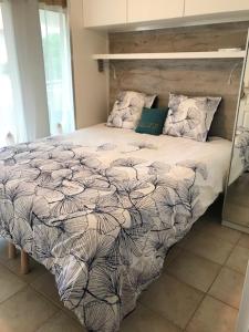 a bedroom with a bed with a black and white comforter at Les calanques in Cavalaire-sur-Mer