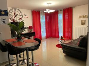 a living room with red curtains and a table and a couch at King Center Superieur in Drancy