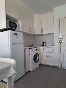 a kitchen with white cabinets and a washer and dryer at Apartamento en Arenal a 5 minutos de la playa in Arenal d'en Castell +10 photos