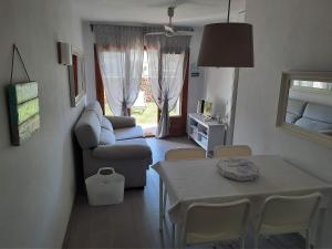 een woonkamer met een tafel en een bank bij Apartamento en Arenal a 5 minutos de la playa in Arenal d'en Castell