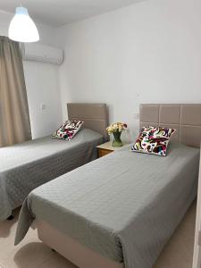a room with two beds and a vase with flowers at Christothea Apartments in Ayia Napa