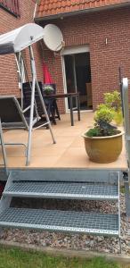eine Terrasse mit einem Tisch, Stühlen und einem Sonnenschirm in der Unterkunft Schöne offene Ferienwohnung mit großer Terrasse. in Bad Münder am Deister