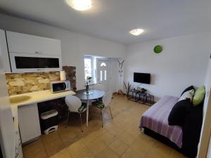 a bedroom with a bed and a kitchen with a table at Apartman Kristina in Vrbnik