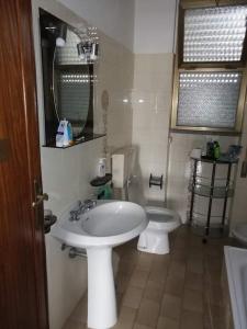 a bathroom with a white sink and a toilet at Appartamento Viareggio in Viareggio