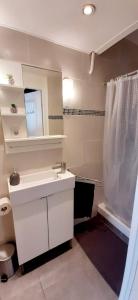 La salle de bains blanche est pourvue d'un lavabo et d'une douche. dans l'établissement Appartement avec terrasse, à Toulon