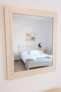 GrikosにあるJoanna Apart - Hotelの鏡にベッドが備わるベッドルームの反射