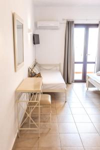 GrikosにあるJoanna Apart - Hotelのベッドとデスクが備わる小さな客室です。