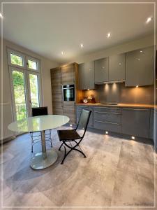 una cocina con mesa de cristal y sillas. en Saar-Apartments, en Merzig