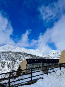 una estación de tren en la nieve con montañas en el fondo en Apartamento en estación de esquí y montaña alto campoo, en Brañavieja