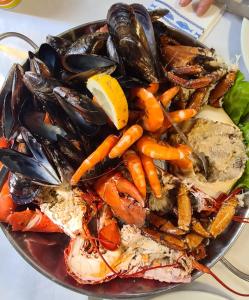 a plate of seafood with mussels and carrots on a table at Casa Beira Rio in Viana do Castelo