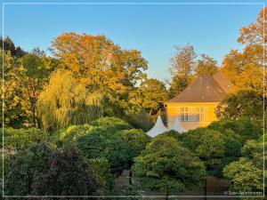 a yellow house in the middle of some trees at Saar-Apartments in Merzig