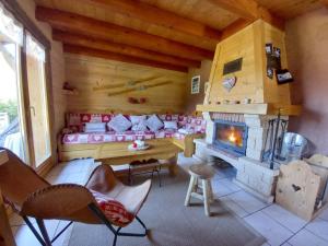 a living room with a fireplace in a log cabin at Chalet Typique Vosgien "les Barbotines" in Ventron