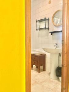 a bathroom with a sink and a toilet and a mirror at Pensión Casa Corro in Carreña de Cabrales