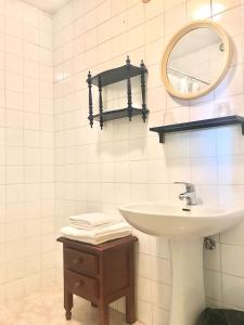 a white bathroom with a sink and a mirror at Pensión Casa Corro in Carreña de Cabrales 