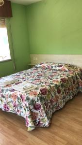 Cama en habitación verde con colcha floral en Pensión Casa Corro en Carreña de Cabrales 