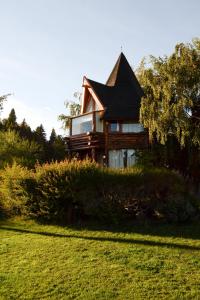 a house sitting on top of a lush green field at La Campiña in San Carlos de Bariloche