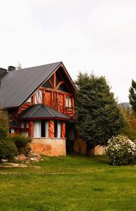 een huis met een zwart dak op een groen gazon bij La Campiña in Bariloche
