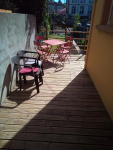 - un ensemble de tables et de chaises sur une terrasse dans l'établissement L'OASIS maisonnette centre ville 3 chambres terrasse espace vert privé parc sainte croix center parc 20 minutes, à Sarrebourg