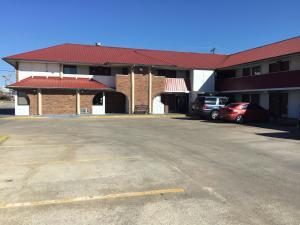 un aparcamiento vacío frente a un edificio en Executive Inn, en Muskogee