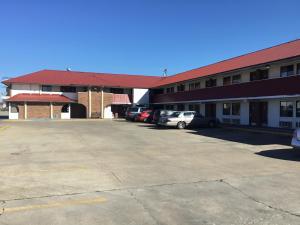 un estacionamiento frente a un edificio en Executive Inn, en Muskogee