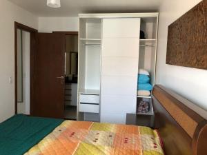 a bedroom with a bed and a closet at Apartamento em Arraial do Cabo in Arraial do Cabo +20 photos