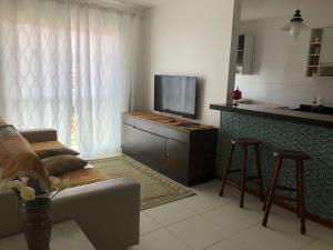 a living room with a couch and a flat screen tv at Apartamento em Arraial do Cabo in Arraial do Cabo
