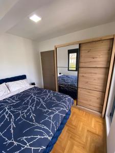 1 dormitorio con 1 cama y suelo de madera en Maya apartman sa dve spavace sobe, en Vrnjačka Banja