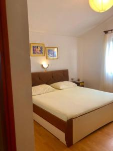 ein Schlafzimmer mit einem Bett in einem Zimmer in der Unterkunft Apartmani Anamar in Supetarska Draga
