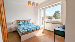 a bedroom with a bed and a window at Słoneczna Przystań - Apartament in Szczedrzyk