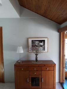 eine hölzerne Kommode mit einer Lampe darüber in der Unterkunft Casa Apartamento de montaña in Espúy