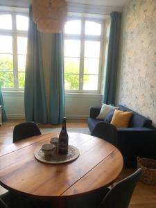 uma sala de estar com uma mesa de madeira e um sofá em L'Aparthé Dinan - Vue sur la place du marché em Dinan