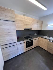 La cuisine est équipée de placards en bois et d'un four avec plaques de cuisson. dans l'établissement Ferienwohnung Sonnenschein, à Bad Aussee