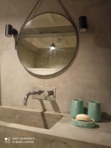 a bathroom with a sink and a mirror on a counter at Casa da Ribeirinha in Ribeirinha
