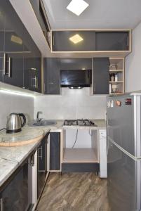 a kitchen with black cabinets and a stainless steel refrigerator at 7/1Exellent apartment in the center of the capital in Yerevan