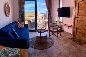 a living room with a blue couch and a large window at Casa Playa in Denia