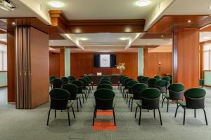 sala konferencyjna z zielonymi krzesłami i podium w obiekcie Hotel Roxy Plaza w mieście Soave