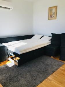 a bed sitting in a room with a couch at Kastellegården Skanskullen in Kungälv +13 photos
