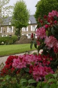 a garden of pink flowers in front of a house at Logis Hotel Du Chateau in Combourg