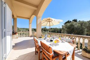 - une table à manger sur une terrasse avec un parasol dans l'établissement Apartments Marta, à Verunić