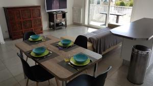una sala de estar con mesa y sillas con platos. en Très beau 3 pièces spacieux lumineux et climatisé en Niza