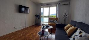 - un salon avec un canapé et une table dans l'établissement Apartment Kovac, à Herceg-Novi