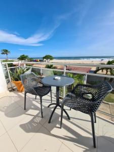 - deux chaises et une table sur un balcon avec vue sur la plage dans l'établissement Superbe vue sur océan, à Pointe-Noire