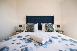 Apartments Marta في Verunić: سرير مع لحاف ووسائد زرقاء وبيضاء