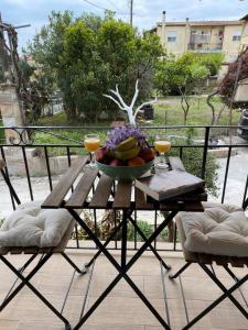 una mesa con un bol de fruta y bebidas en el balcón en Villa Loukia, en Corfú