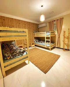 een kamer met 2 stapelbedden en een tapijt bij Bohemian style in Abha