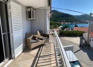 a balcony with two chairs and a view of the water at Boomerang Apartments in Klek