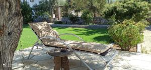 une chaise assise à côté d'un arbre dans une cour dans l'établissement Olive Garden, à Lapta