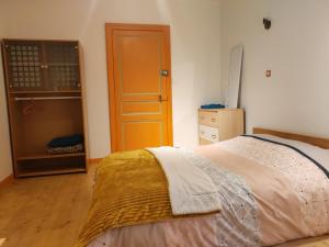 a bedroom with a bed and a wooden door at Chambre chez l habitante "Lys des incas" in Derval