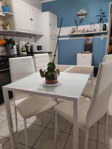 a white dining room table with white chairs at Chambre chez l habitante "Lys des incas" in Derval